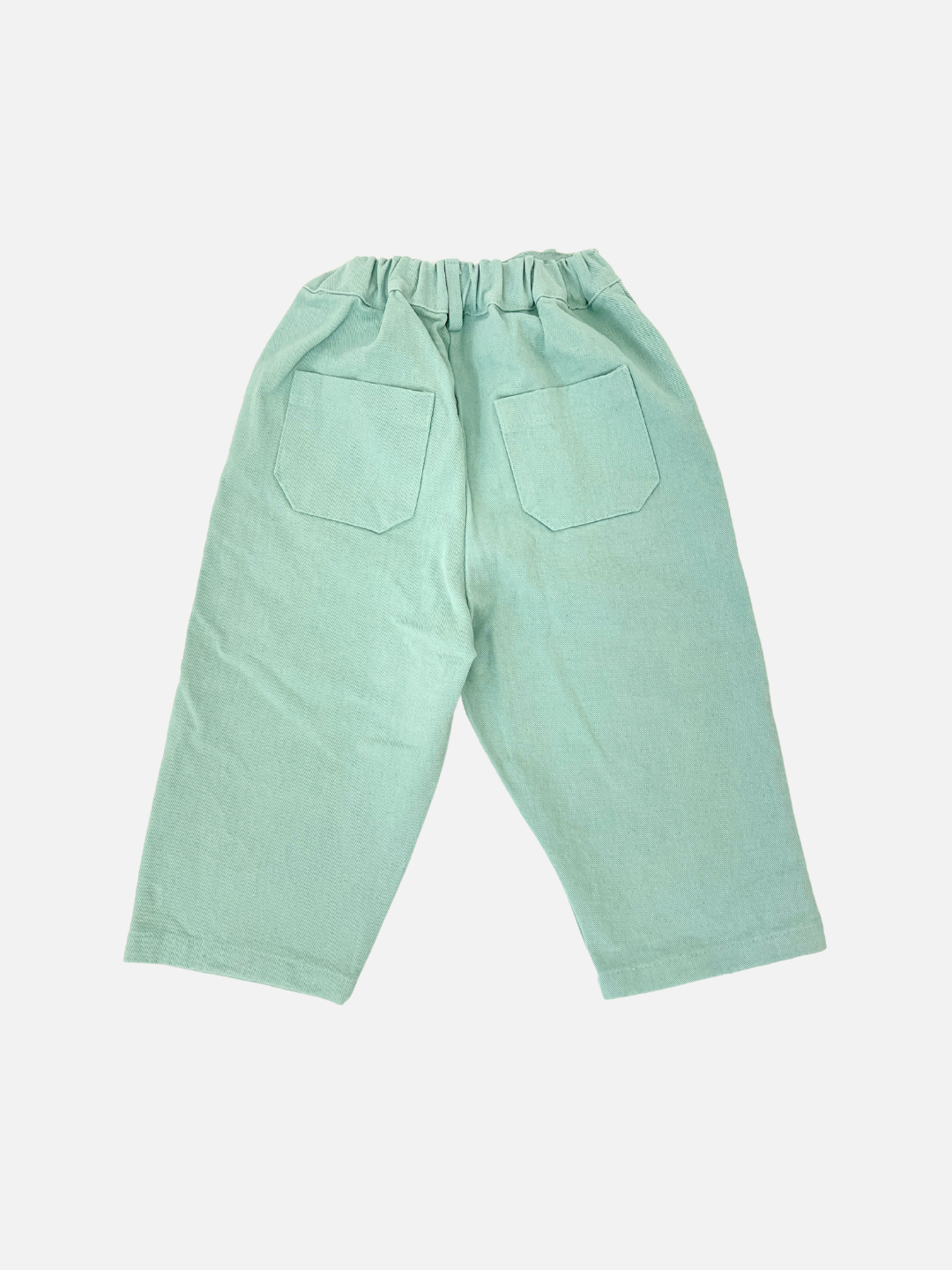 Mint | The Tomboy Pants are slouchy, light green, crafted from soft cotton twill with an elastic waistband and two rear pockets. They showcase a stylish design from a popular Korean kids brand on a clean white background.