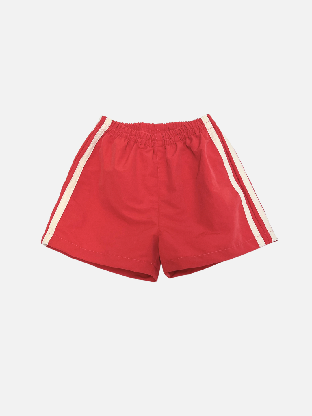 SPRINTER SHORTS in Vintage Red, featuring an elastic waistband and white vertical side stripes, displayed on a plain white background.