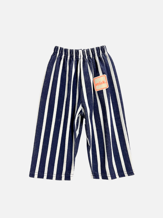 Image of Front view of the Paint Roller Pants in Terry fabric white/navy stripes. "Stick" patch logo on the left leg in cream and orange. 