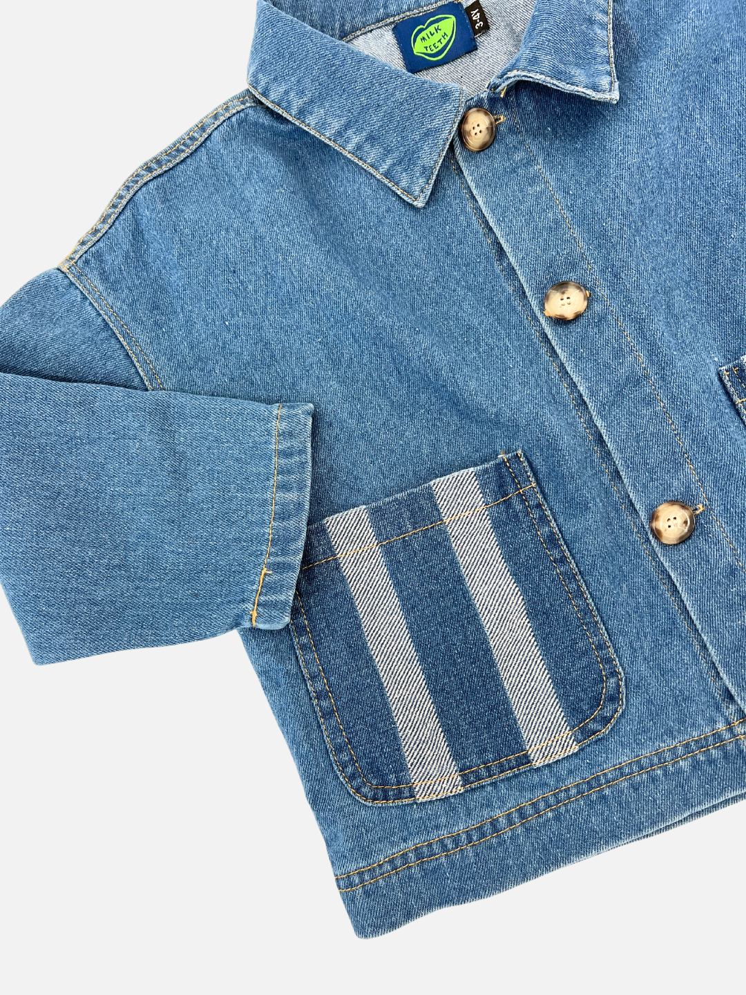 Medium Wash | The STRIPE POCKET CHORE COAT is made from denim and includes beige buttons, a collar, striped patch pockets, and a distinctive blue label on the inside.