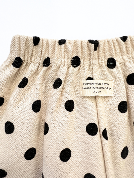 Second image of POLKA DOT PANT: Beige children's pants with a relaxed fit, elastic waistband, and black polka dot pattern in soft double-layer cotton, shown on a white background.