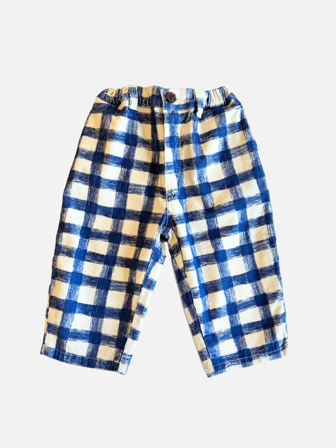 Front view of kids corduroy trousers in white with a large blue grid check pattern.
