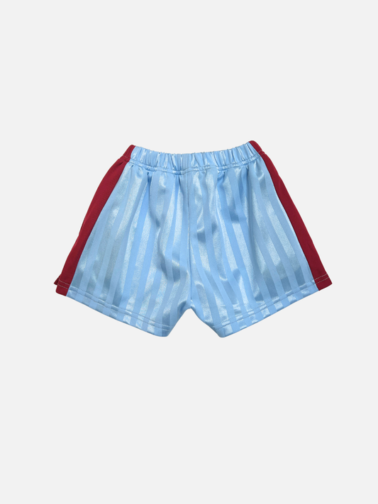 Second image of Front view of light blue kids shorts in shiny sport mesh fabric with maroon red side stripes on a light gray background