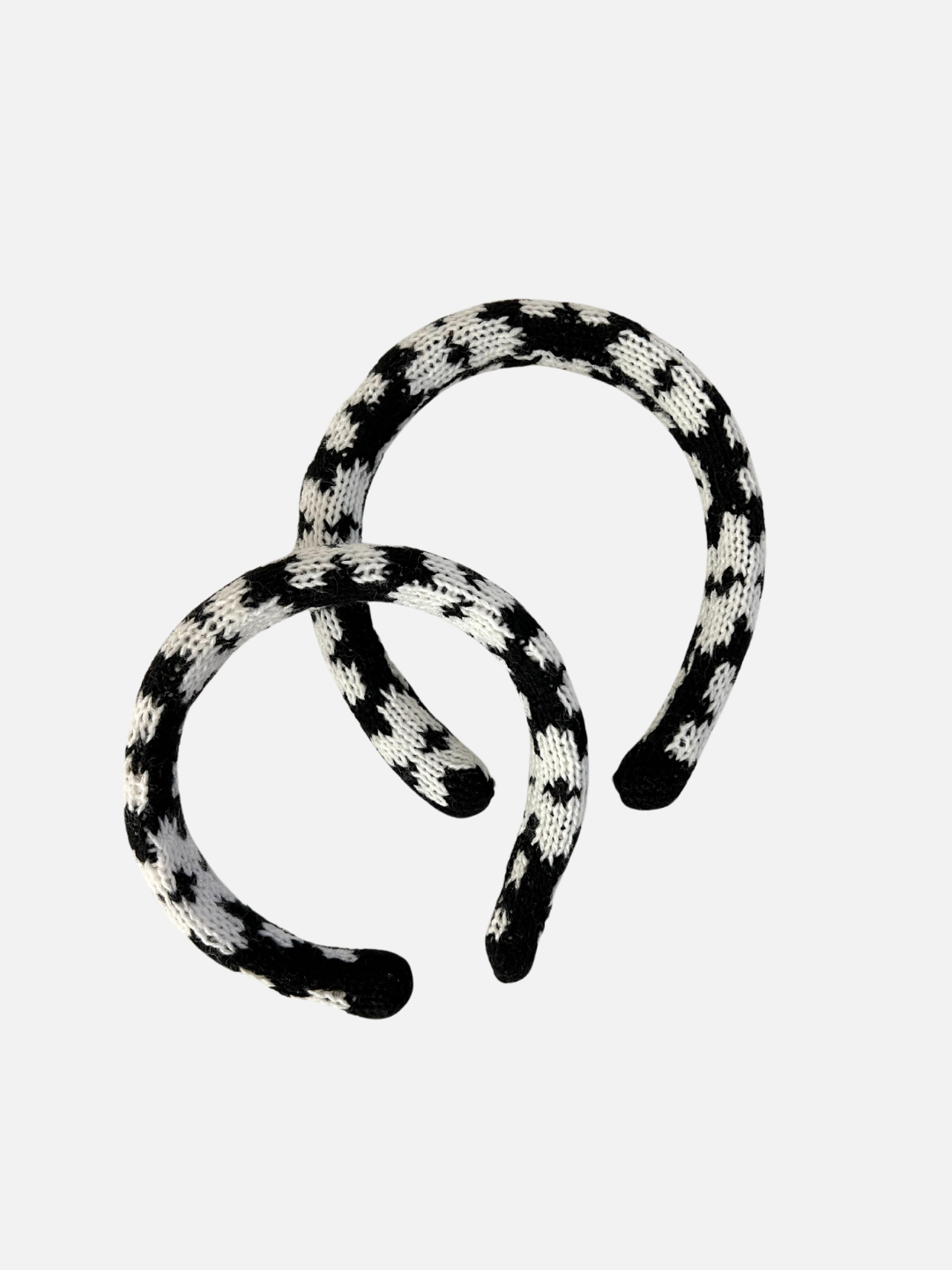 Two sizes of kids' knitted headband in pattern of white flowers on a black background