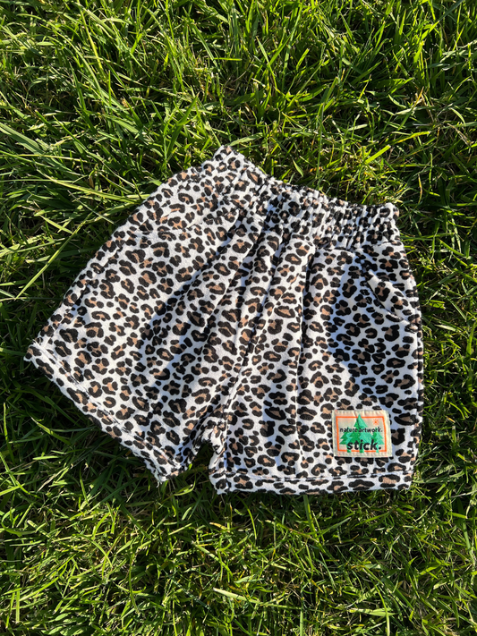 Second image of Front view of the kids' Leopard print terrycloth shorts. Stick brand logo on the right leg.