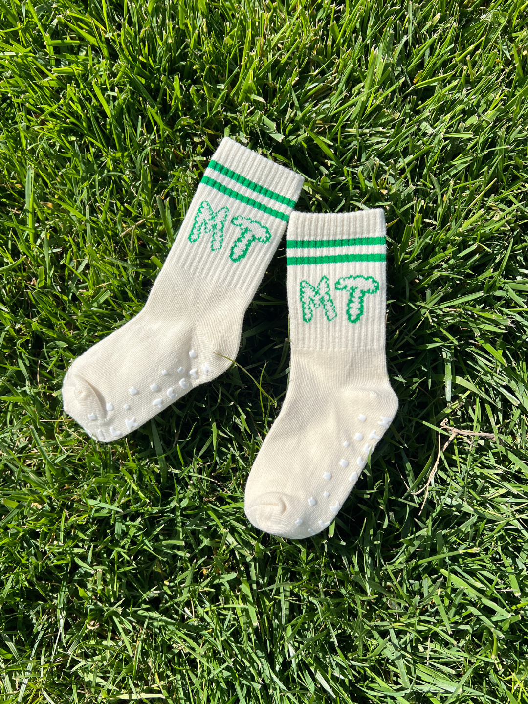 Green | White socks with green stripes and 'MT' logo on grass