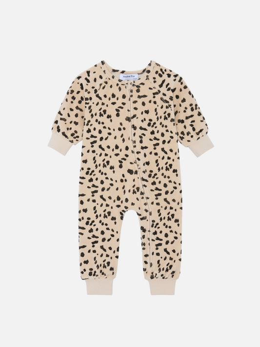 Image of The DALMATIAN TERRY SLEEPSUIT is a beige baby onesie with black speckles, featuring long sleeves, a front zipper, and cuffs at the sleeves and ankles. It's perfect for your baby and new arrivals section—be sure to check the price during your next merchandising review.