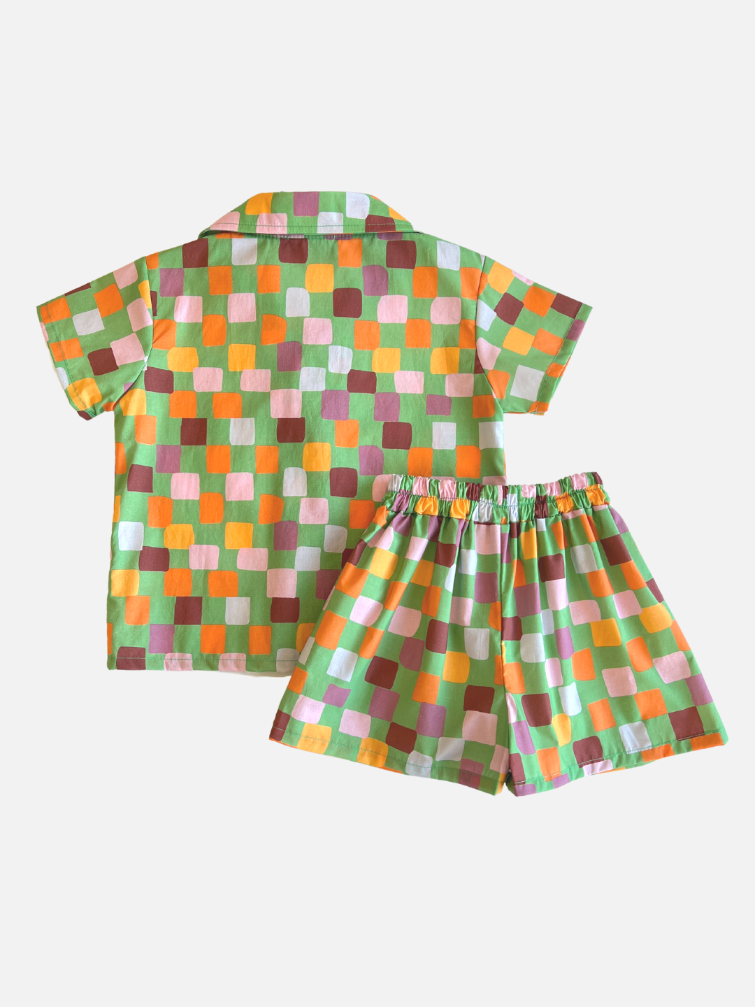 A kids' shirt and shorts set in a pattern of purple, pink, gold and orange squares on a green background, back view