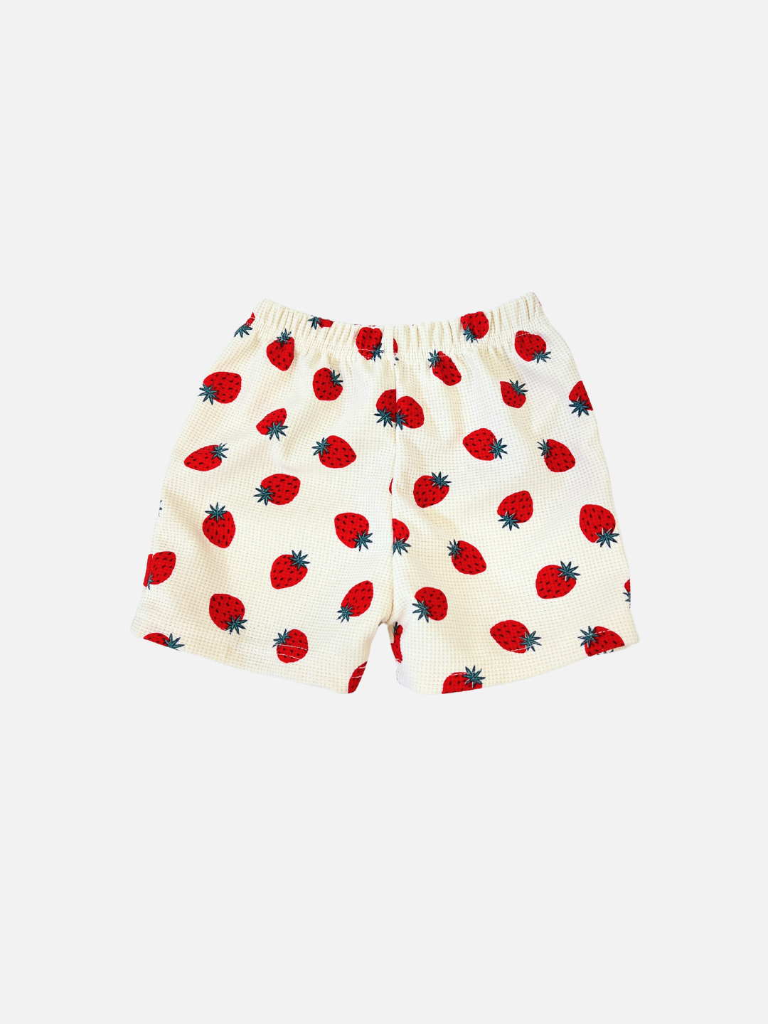 STRAWBERRY WAFFLE SHORTS are white shorts featuring a charming strawberry pattern, with red strawberries and green leaves on a plain background.