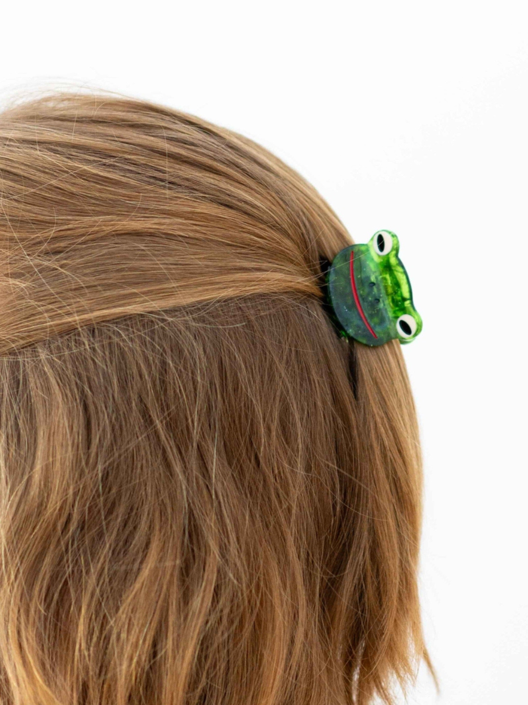 Green froggy hairclip on a half up half down hairstyle
