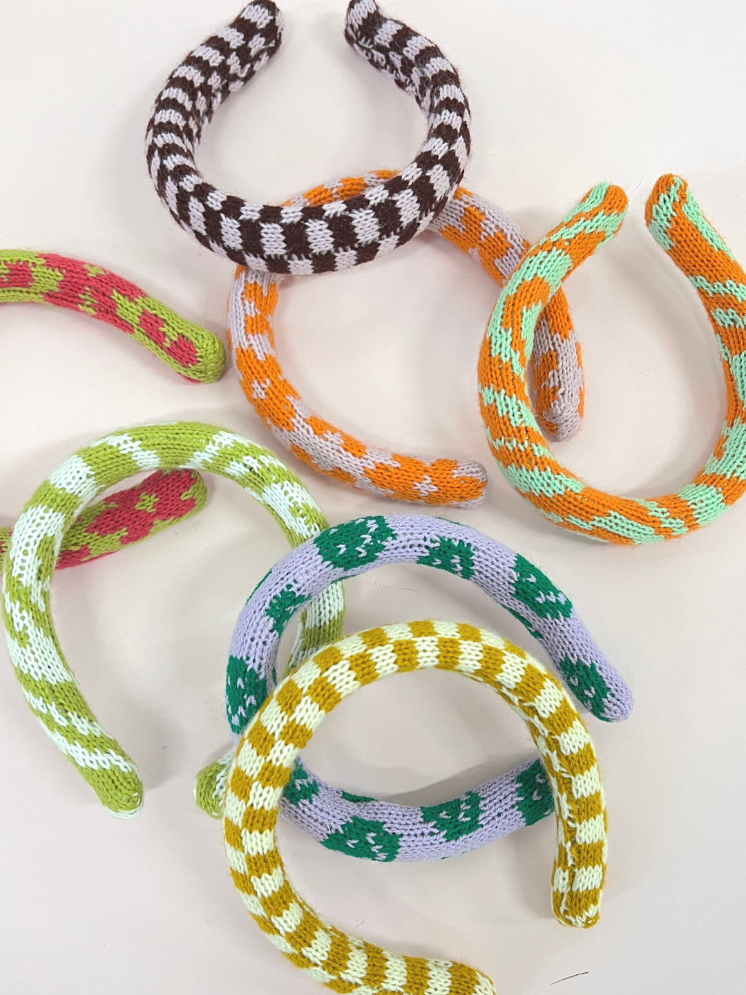 A collection of kids' knitted headbands in various colors and patterns