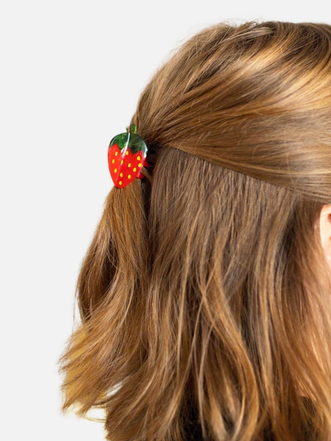 Mini strawberry clip holding a half up half down hairstyle