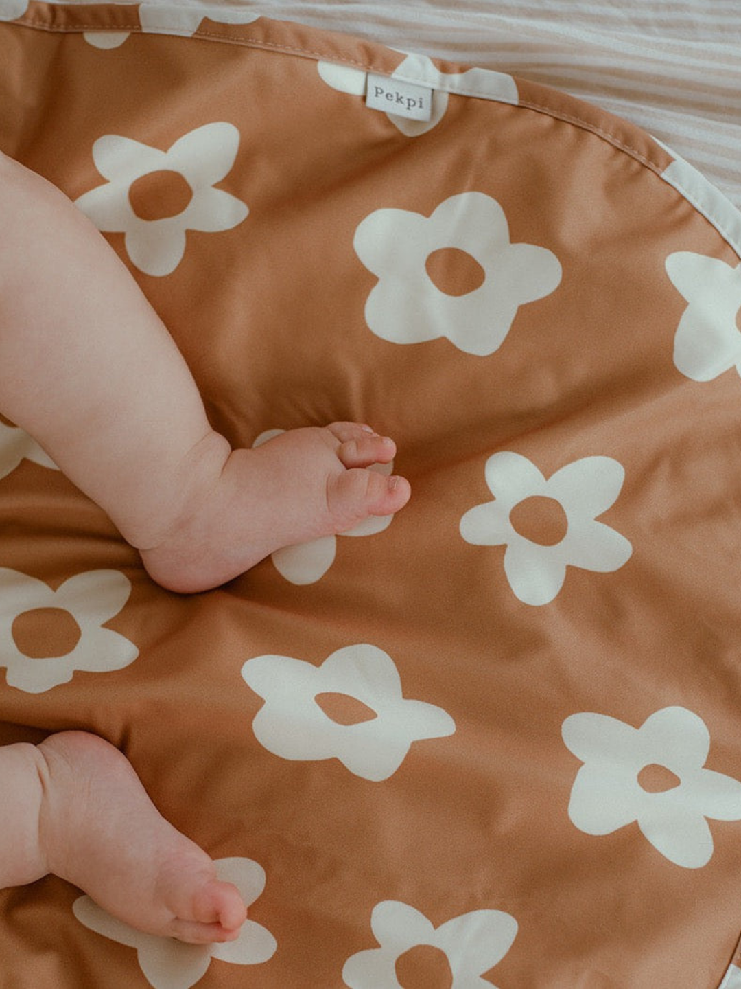 Posy | Baby in a swim diaper laying on the change mat in Posy print