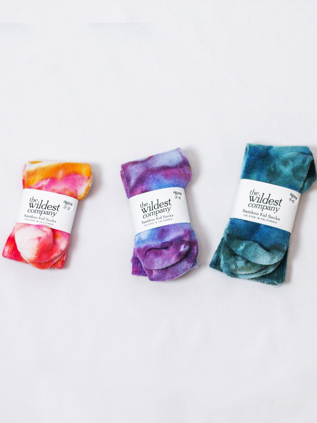 Ultraviolet | Three pairs of socks laid flat highlighting the Wildest Company paper packaging