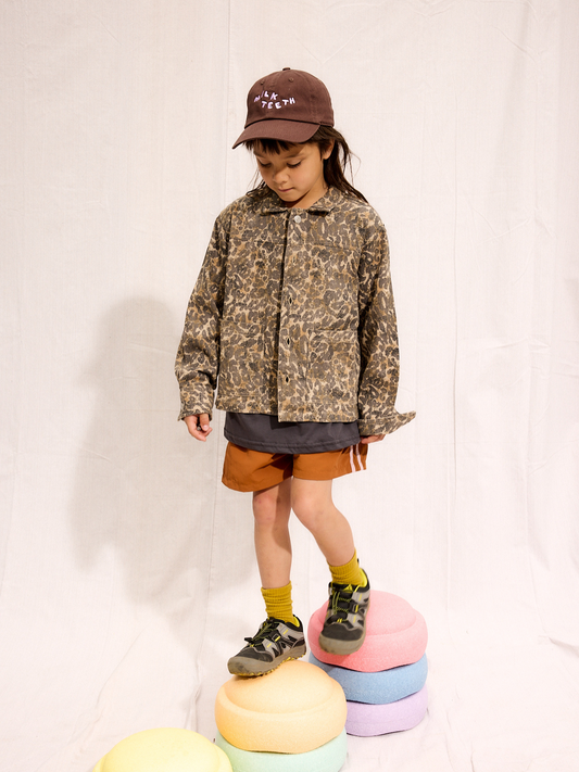 Second image of The FEN LEOPARD JACKET is an oversized piece with long sleeves, showcasing a chic gray and brown leopard pattern. Made from organic cotton, it features a convenient front button closure.