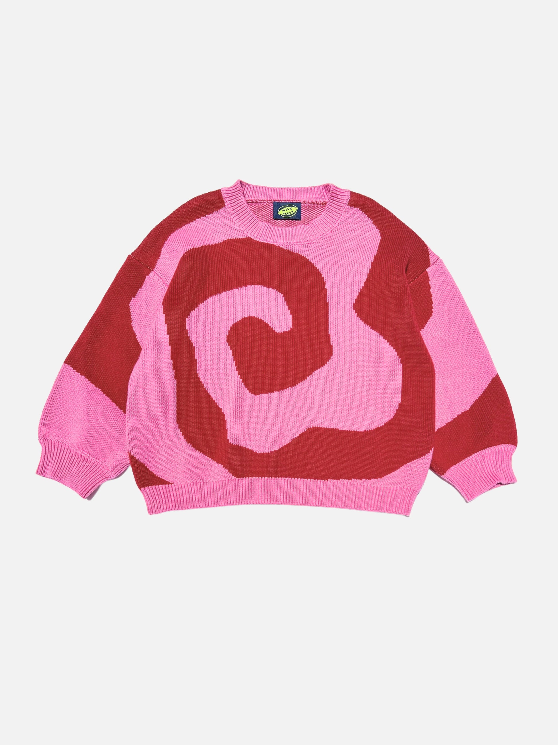 Front view of kids crewneck sweater in bright pink, with a large single red swirl design that covers the entire sweater.