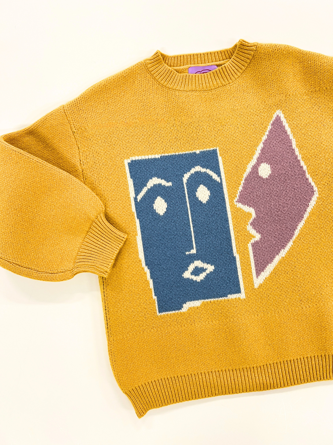 Marigold | TEATIME SWEATER in yellow features an abstract face design in blue and purple on the front. For a perfect fit, please refer to the measurements provided in the photos.