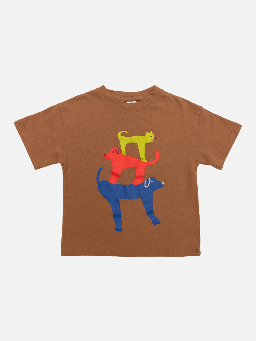 Mocha | Child wearing a brown t-shirt with colorful cat designs, gray cap, gray pants, and orange Crocs standing against a white wall.