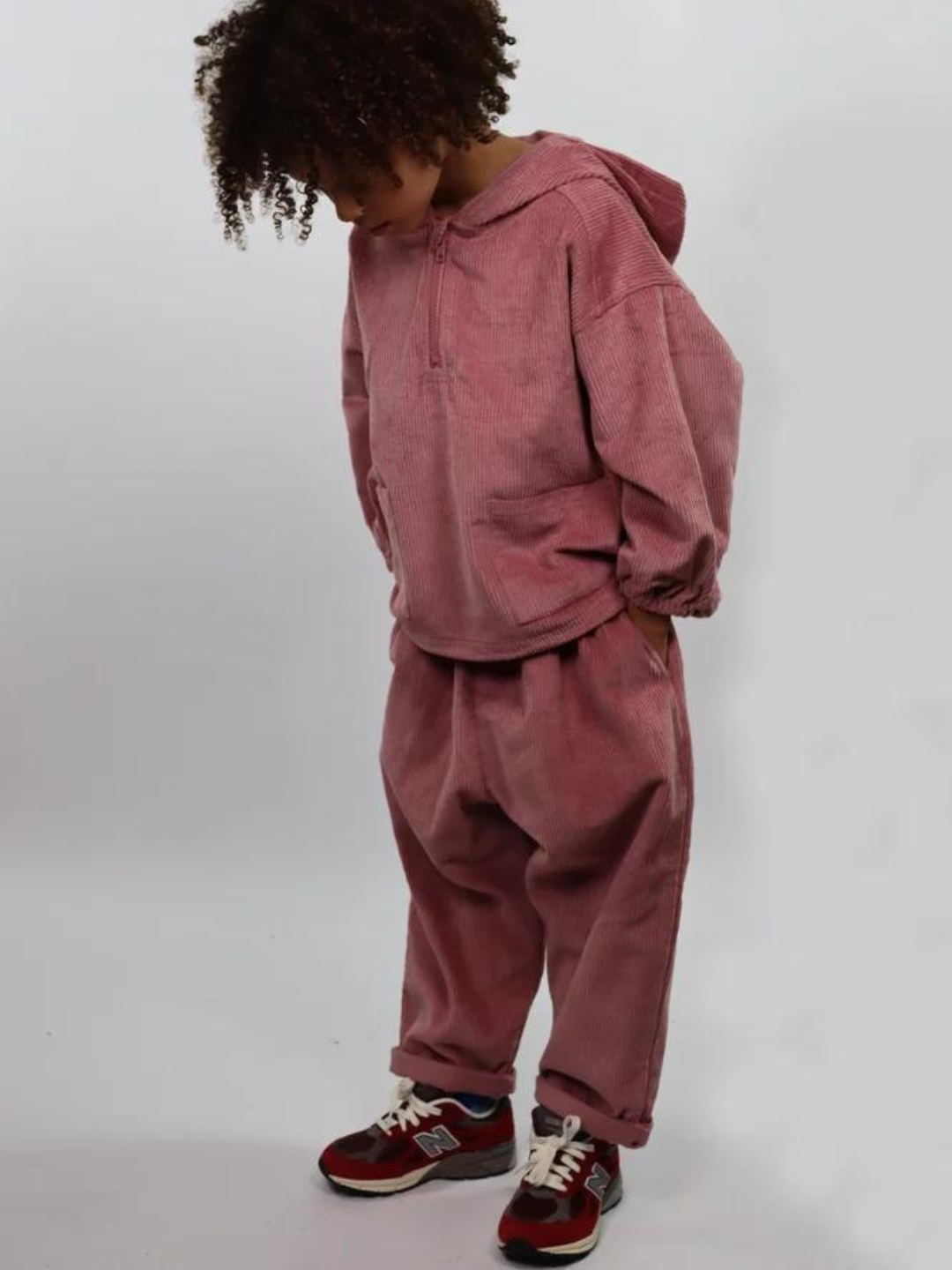 Child wearing dusty pink kids' hooded smock and pants