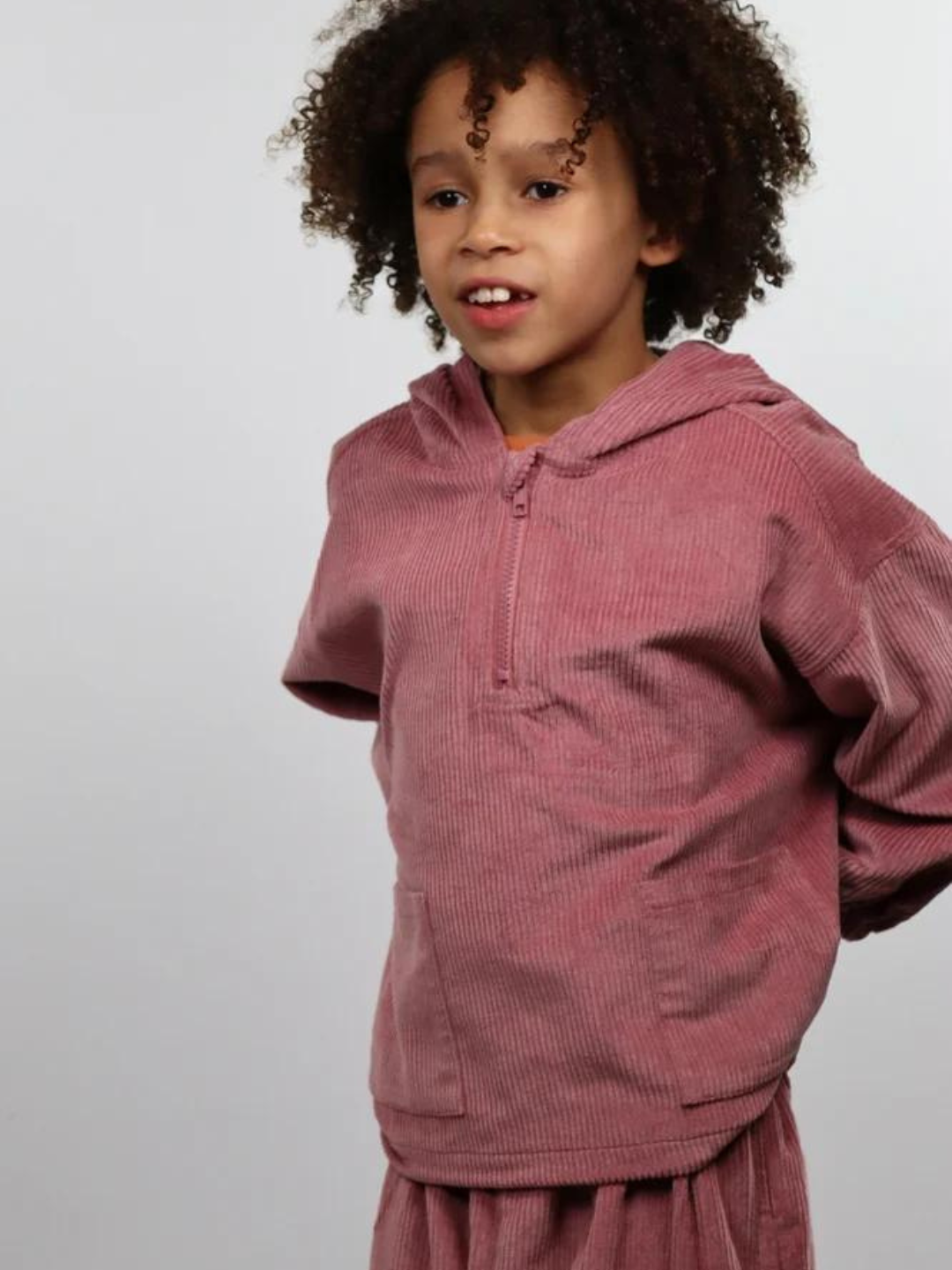 A child wearing a kids' hooded smock top in dusty pink