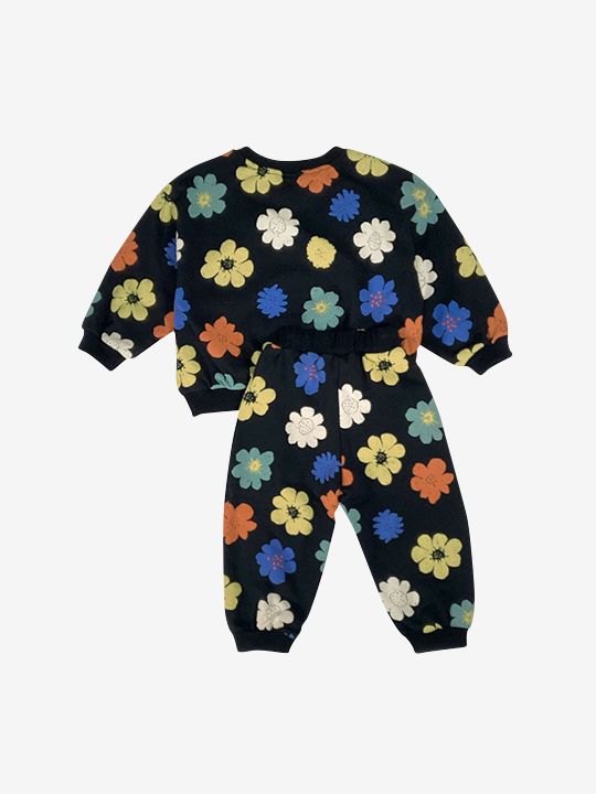 A kids' sweatshirt and pants set in black, printed with yellow, orange, green, blue and white flowers, back view