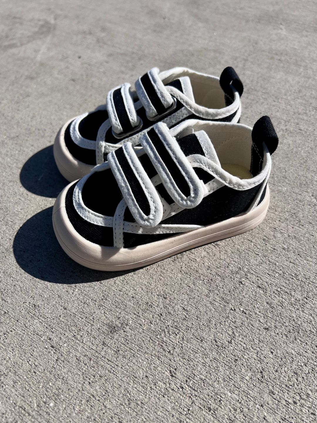 Pair of kids' sneakers in black with white trim