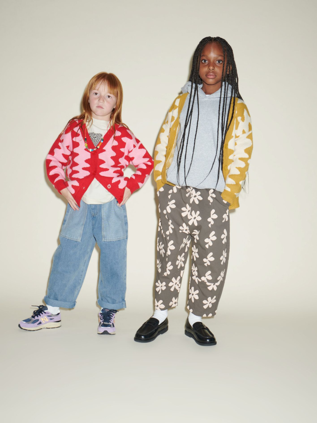 Two children wearing Wavelength Cardigans, the child on the right in gray pants with cream flowers