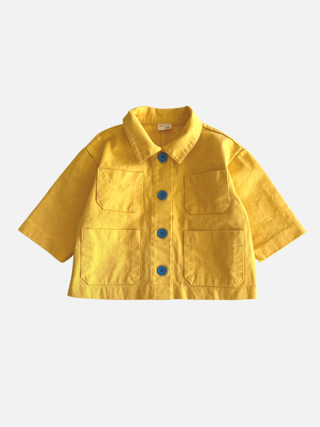 A kids' jacket in yellow, with four pockets and four blue buttons
