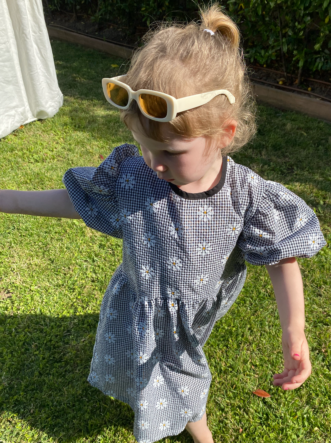 Ivory Matte | A child wearing a pair of kids' sunglasses with cream frames and brown lenses