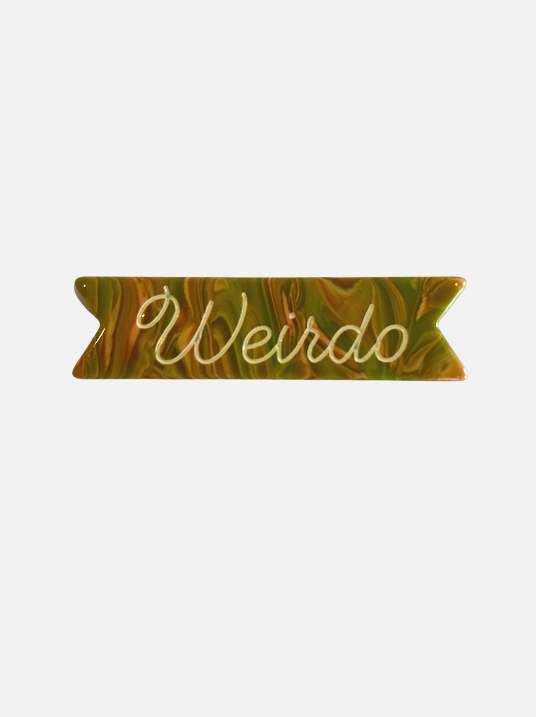 A kids' hair clip with the word Weirdo on a swirly green and orange background