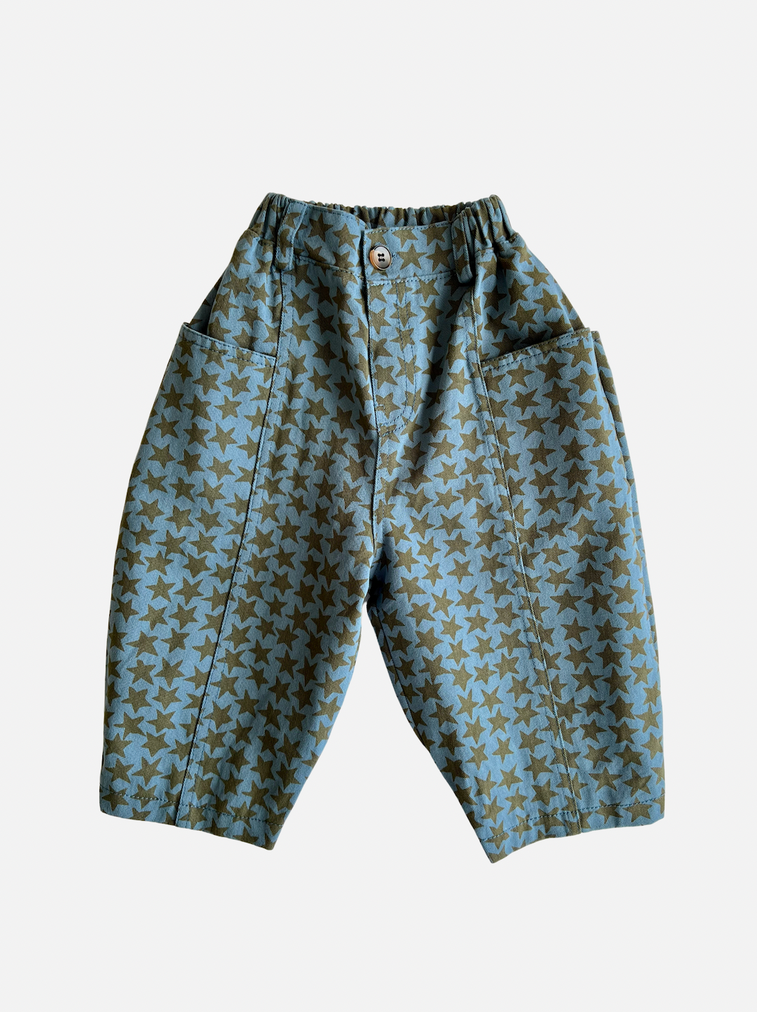 A pair of kids' pants in slate blue with a pattern of olive green stars, and generous side pockets