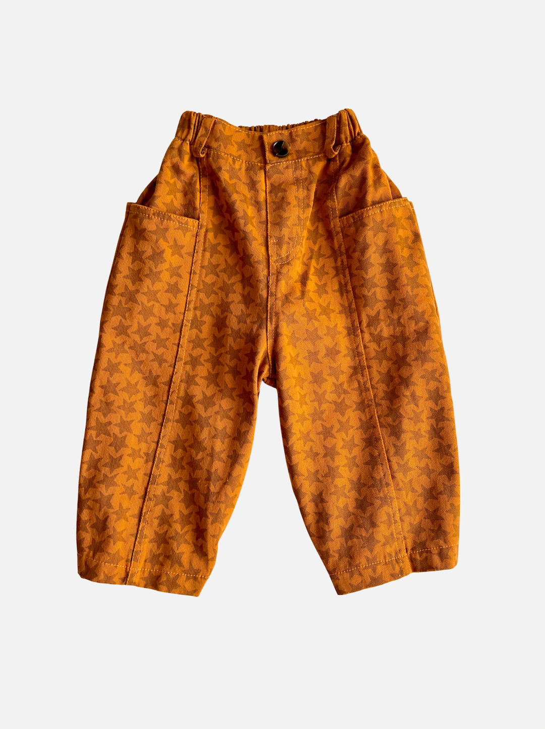 Rust | A pair of kids' pants in orange with a pattern of rust stars, with two long side pockets