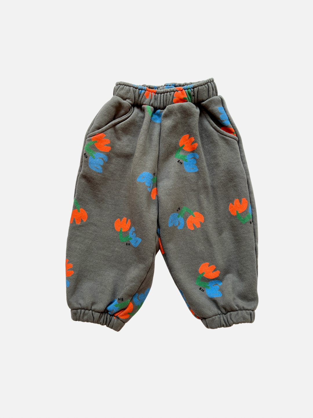 Pair of kids' sweatpants with orange and blue flowers on a slate gray background, front view