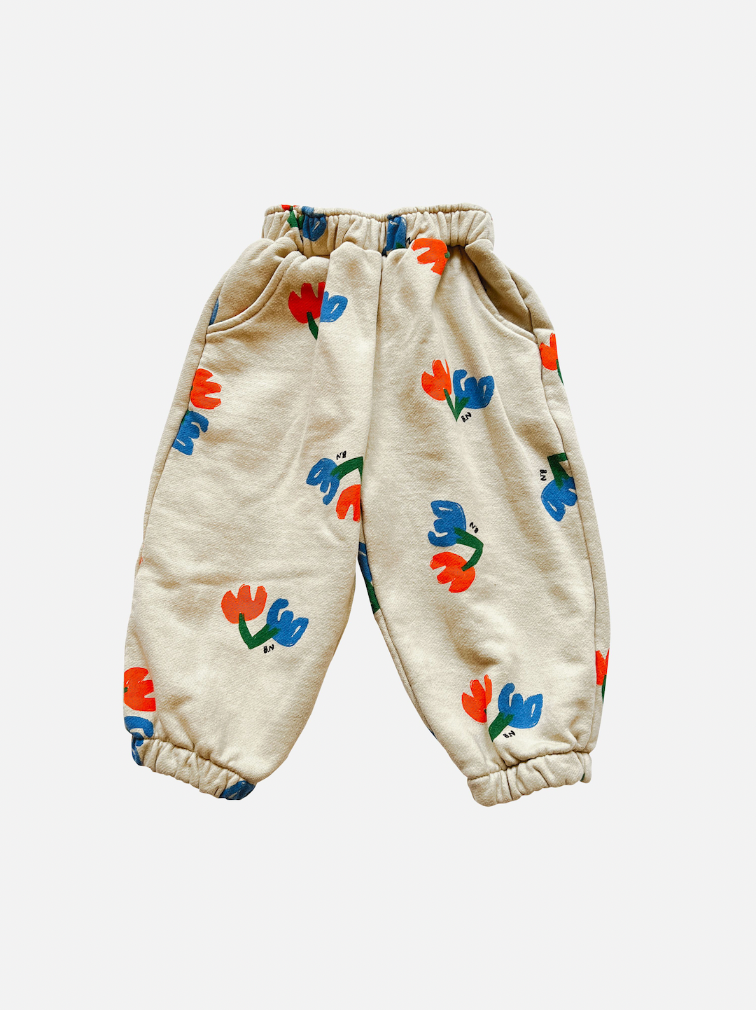 Pair of kids' sweatpants with blue and red flowers printed on ecru background