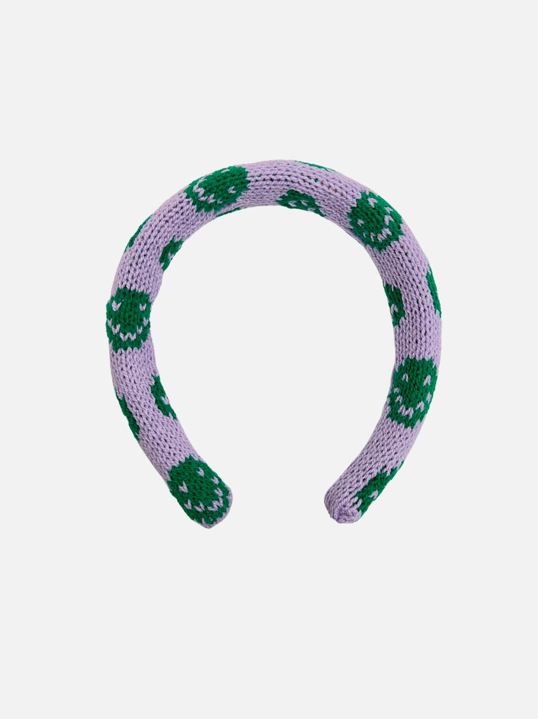 A kids' knitted headband with green smileys on a purple background