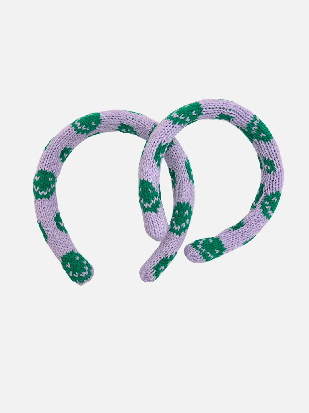 Two sizes of kids' knitted headband with green smileys on a purple background