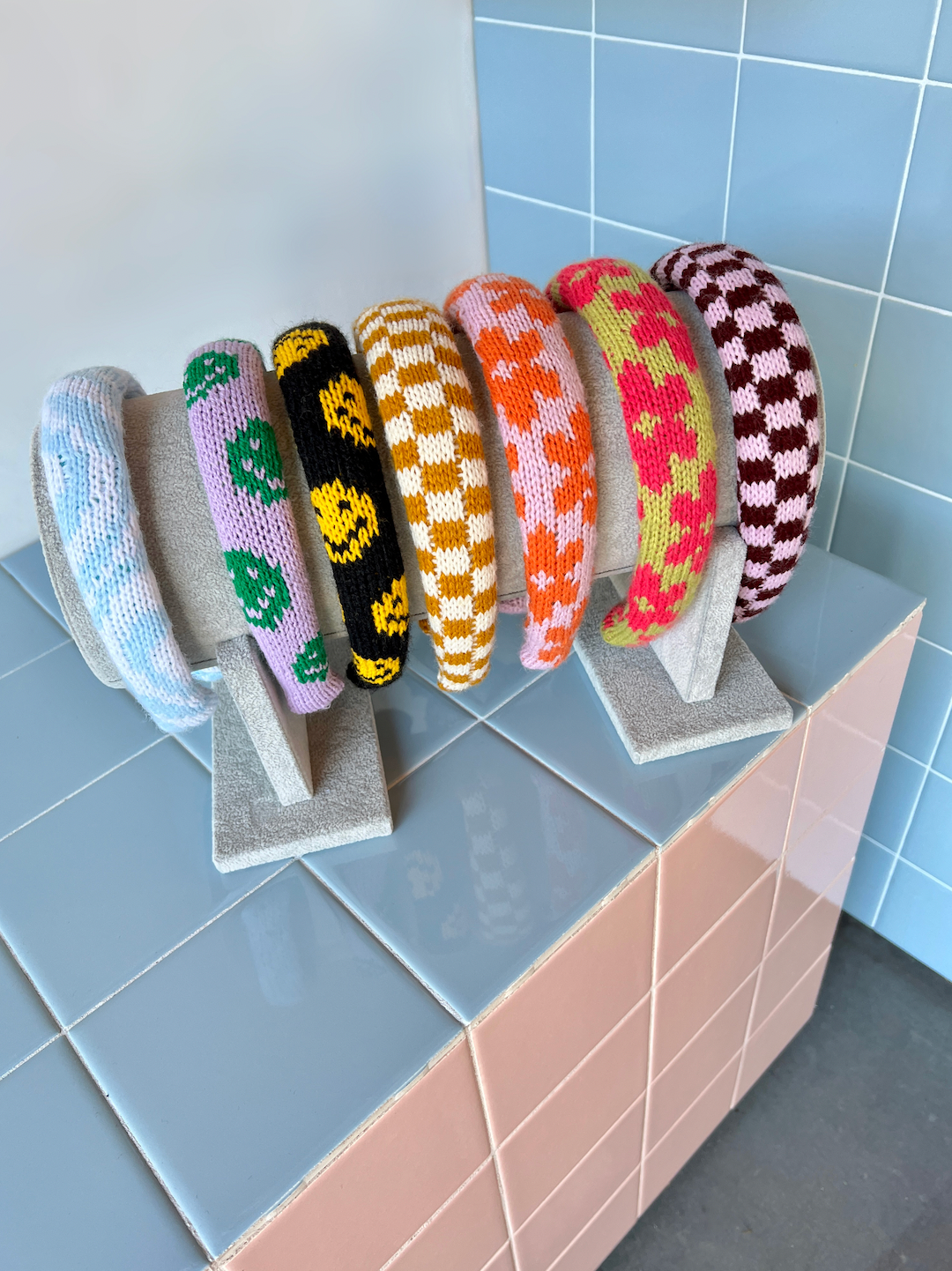 A dissplay of kids' knitted headbands in various colors and patterns