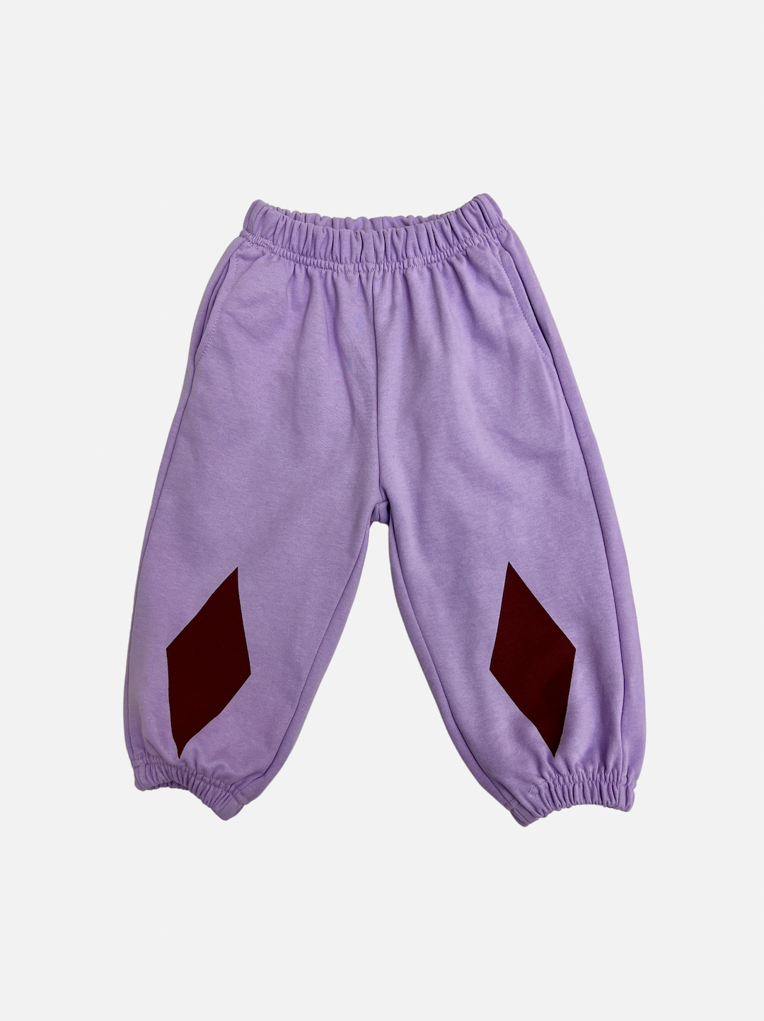 A pair of kids' sweatpants in pale purple with dark red diamond patches at the knees